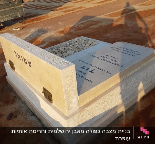 מצבה עם כיתוב בעברית ואבנים קטנות